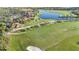 Scenic aerial view of the golf course and clubhouse with beautiful landscaping and lake views at 23590 Copperleaf Dr, Venice, FL 34293