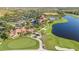 Beautiful aerial view featuring lush landscaping, clubhouse, pool, tennis courts and lake views at 23590 Copperleaf Dr, Venice, FL 34293