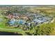 Aerial view showing the community pool, tennis courts, clubhouse, lush landscaping, and lake at 23590 Copperleaf Dr, Venice, FL 34293