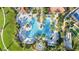 Aerial image offering top-down view of the sparkling community pool, palms, and tennis courts at 23590 Copperleaf Dr, Venice, FL 34293