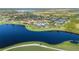 Expansive aerial shot featuring lush landscaping, lake, tennis courts, community pool and clubhouse at 23590 Copperleaf Dr, Venice, FL 34293