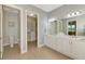 Bright bathroom featuring double sinks, walk in closet, and a separate toilet area at 23590 Copperleaf Dr, Venice, FL 34293