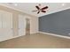Empty bedroom with tile floors, ceiling fan, and access to an adjacent bathroom and closet at 23590 Copperleaf Dr, Venice, FL 34293