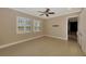 Empty bedroom with tile floors, plantation shutters, ceiling fan, and access to an adjacent room at 23590 Copperleaf Dr, Venice, FL 34293
