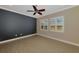 Empty bedroom with tile floors, plantation shutters, ceiling fan, and a modern accent wall ready to be personalized at 23590 Copperleaf Dr, Venice, FL 34293