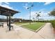 Community bocce ball courts featuring shade structures, manicured lawns, benches, and pathway at 23590 Copperleaf Dr, Venice, FL 34293