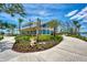Modern clubhouse with lush landscaping, a sidewalk, and a view of the lake, perfect for community gatherings at 23590 Copperleaf Dr, Venice, FL 34293