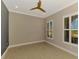 Bright, empty room with two shuttered windows and a ceiling fan at 23590 Copperleaf Dr, Venice, FL 34293