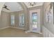 Elegant foyer with decorative glass front door and arched entryway into adjacent room at 23590 Copperleaf Dr, Venice, FL 34293