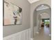 Hallway with decorative paneling and arched entryway leading into open concept living area at 23590 Copperleaf Dr, Venice, FL 34293