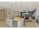 Spacious kitchen area open to the living room, features a large island and views of the outdoor living area at 23590 Copperleaf Dr, Venice, FL 34293
