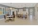 Kitchen with dining area featuring an island, stainless steel appliances, and modern pendant lighting at 23590 Copperleaf Dr, Venice, FL 34293