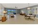 Open living and dining area with neutral tones, tile flooring, and sliding glass doors to the lanai at 23590 Copperleaf Dr, Venice, FL 34293