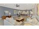 Bright living room features stylish decor, tile flooring, ceiling fan, and an open floor plan with access to the kitchen at 23590 Copperleaf Dr, Venice, FL 34293