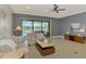 Bright living room features stylish decor, tile flooring, ceiling fan, and a sliding glass door with a view of the outdoor pool at 23590 Copperleaf Dr, Venice, FL 34293