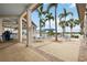 Outdoor dining at community bar with tables, chairs and umbrellas surrounded by palm trees at 23590 Copperleaf Dr, Venice, FL 34293