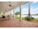 Spacious covered patio with brick floor and outdoor furniture overlooking scenic lake at 23590 Copperleaf Dr, Venice, FL 34293