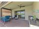 Covered patio featuring ceiling fans, an outdoor kitchen, and comfortable seating area at 23590 Copperleaf Dr, Venice, FL 34293
