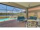 Screened-in patio showcasing seating, spa, and a view of the pond at 23590 Copperleaf Dr, Venice, FL 34293