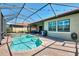 Screened-in pool and spa with a brick patio and backyard access at 23590 Copperleaf Dr, Venice, FL 34293