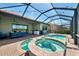 Screened-in pool and spa area with outdoor kitchen, lounge chairs and a view at 23590 Copperleaf Dr, Venice, FL 34293