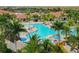 Lovely view of sparkling community pool, palm trees, patio furniture, and community buildings at 23590 Copperleaf Dr, Venice, FL 34293