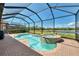 Screened-in pool and spa with a brick patio overlooks a serene pond at 23590 Copperleaf Dr, Venice, FL 34293