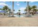 Stunning view of the community pool lined with palm trees, umbrellas, and lounge chairs at 23590 Copperleaf Dr, Venice, FL 34293