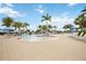 Beautiful community pool surrounded by palm trees, lounge chairs, and blue umbrellas at 23590 Copperleaf Dr, Venice, FL 34293
