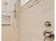 Close up of a modern tiled shower with hand held faucet, built in niche, and neutral color palette at 23590 Copperleaf Dr, Venice, FL 34293