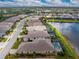 Aerial view of the property with a screened-in pool overlooking the lake, surrounded by lush greenery, and a red property outline at 257 Corelli Dr, Nokomis, FL 34275