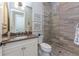 Elegant bathroom showcasing a spacious glass shower with gray wood-look tiling, a vanity, and toilet at 257 Corelli Dr, Nokomis, FL 34275
