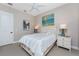 Serene bedroom features a ceiling fan, plantation shutters, neutral walls, side tables, and hardwood floors at 257 Corelli Dr, Nokomis, FL 34275