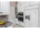 Modern kitchen features white cabinets, stainless appliances and adjacent pantry space at 257 Corelli Dr, Nokomis, FL 34275