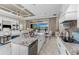 Open-concept kitchen featuring white cabinets, granite countertops, and a view of the outdoor dining area and pool at 257 Corelli Dr, Nokomis, FL 34275