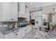 Kitchen features white cabinets, modern appliances, tiled backsplash, and granite countertops with a sink at 257 Corelli Dr, Nokomis, FL 34275