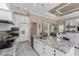 Bright kitchen with white cabinets, granite countertops, stainless steel appliances, and a view of the living space at 257 Corelli Dr, Nokomis, FL 34275