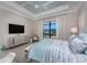 Comfortable bedroom with tray ceiling, TV and view of the pool at 257 Corelli Dr, Nokomis, FL 34275