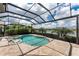 A screened in pool and spa with lush landscaping and lake views at 257 Corelli Dr, Nokomis, FL 34275
