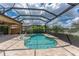 A screened in pool and spa with in-pool seating, lush landscaping, and lake views at 257 Corelli Dr, Nokomis, FL 34275