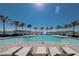 Resort-style pool with poolside lounge chairs, striped cabanas, and lake views at 257 Corelli Dr, Nokomis, FL 34275