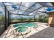 Screened-in pool with an in-ground hot tub overlooking a lake at 257 Corelli Dr, Nokomis, FL 34275