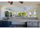 Outdoor kitchen and bar featuring granite countertops, dark cabinets, and overhead ceiling fans at 257 Corelli Dr, Nokomis, FL 34275