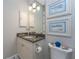 Charming powder room with a granite countertop vanity, decorative art, and a stylish toilet at 257 Corelli Dr, Nokomis, FL 34275