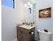 Stylish powder room featuring a granite countertop vanity with decor and an ornate framed painting at 257 Corelli Dr, Nokomis, FL 34275