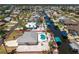 Aerial view of a home with a pool and canal in a residential neighborhood at 2673 Titania Rd, Englewood, FL 34224