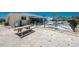 Backyard with metal fence, gravel, picnic table, trees, and pool at 2673 Titania Rd, Englewood, FL 34224