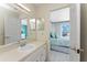 Bright bathroom featuring a vanity with a framed mirror, a door, and a main bedroom entrance at 2673 Titania Rd, Englewood, FL 34224