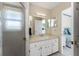 Bright bathroom featuring a sink with vanity, framed mirror, glass shower, and a Primary bedroom entrance at 2673 Titania Rd, Englewood, FL 34224