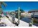 Private backyard dock featuring boat lift, green canopy, and white shell landscaping on the canal at 2673 Titania Rd, Englewood, FL 34224